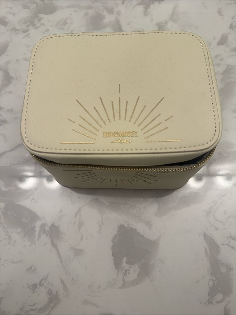 Biossance Cream Cosmetic Travel Case with Gold Sunburst Detail
